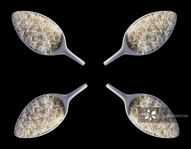 四个瓷勺与生长米在黑色背景上。图片素材