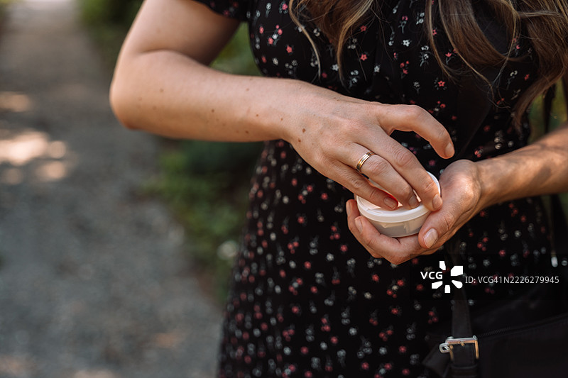 女人打开一罐白色的尼古丁袋图片素材