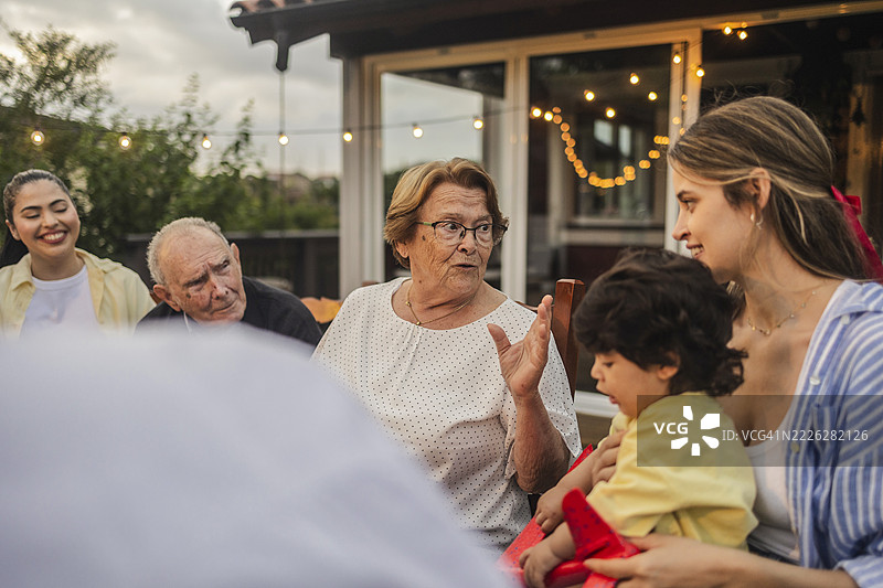 快乐的家庭在露台上享受节日晚餐图片素材