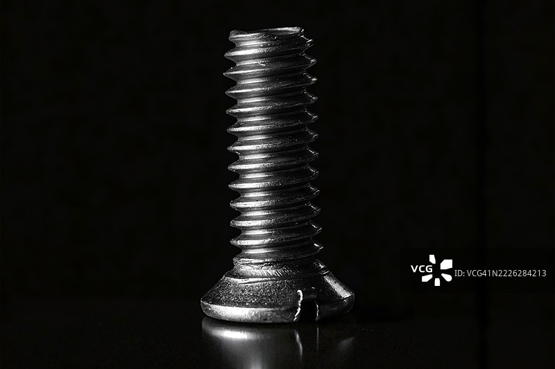 黑色背景上的工业金属螺丝图片素材