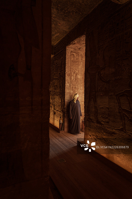 游客在埃及阿布辛贝神庙内观察古代象形文字。图片素材