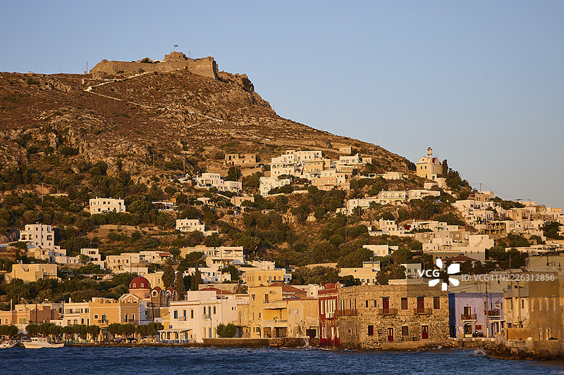 希腊海滨村庄潘泰利城堡，背景是夕阳下的山丘，拥有传统建筑，位于希腊多德卡尼斯群岛的莱罗斯岛的圣玛丽娜。图片素材