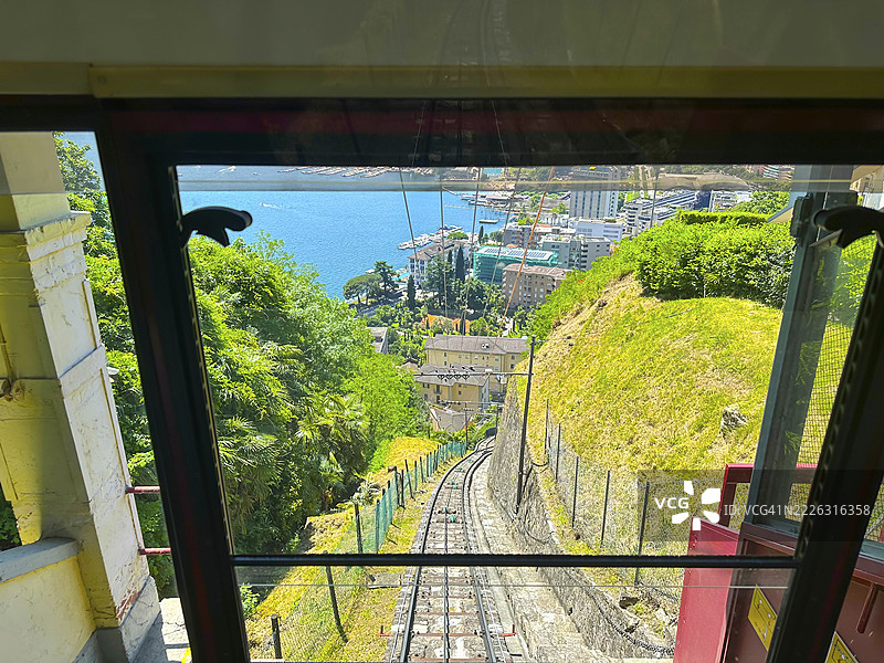 从缆车俯瞰瑞士提契诺州卢加诺湖、山景和城市风光的全景，阳光明媚的夏日。图片素材