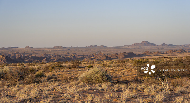 黄昏时分的沙漠景观，夕阳下的荒凉地貌，堆叠岩石的山丘，埃龙戈，达马拉地区，纳米比亚图片素材