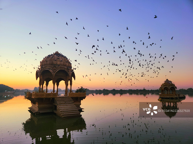鸟儿在拉贾斯坦邦杰萨尔梅尔的加迪萨尔湖上空飞翔图片素材