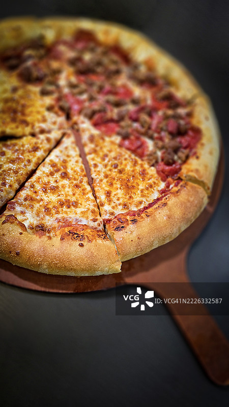 美味的比萨，配有奶酪和肉类爱好者的浑合配料，放在木板上。金黄色的奶酪填充边，AR，必胜客，906 E Beebe Capps Expy，Searcy，72143，美国图片素材