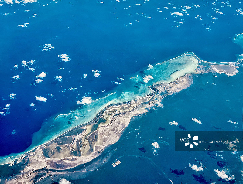 从飞机窗户俯瞰加勒比海的鸟瞰图，蓝色海洋和热带云彩，卡马圭，古巴，美国图片素材