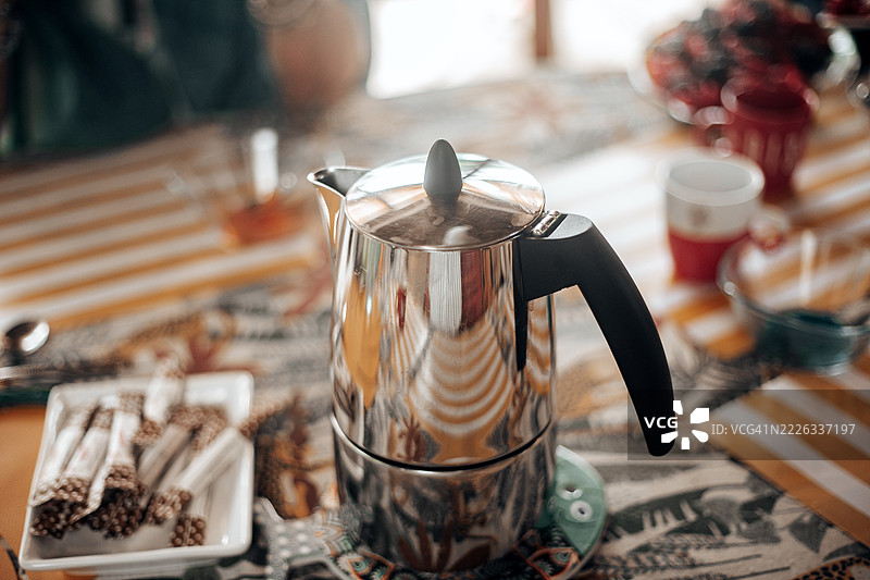 经典的意大利金属炉顶咖啡壶，也称为摩卡壶，放置在桌子上。图片素材