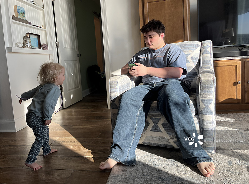 小女孩在海滩度假时与哥哥玩耍。图片素材