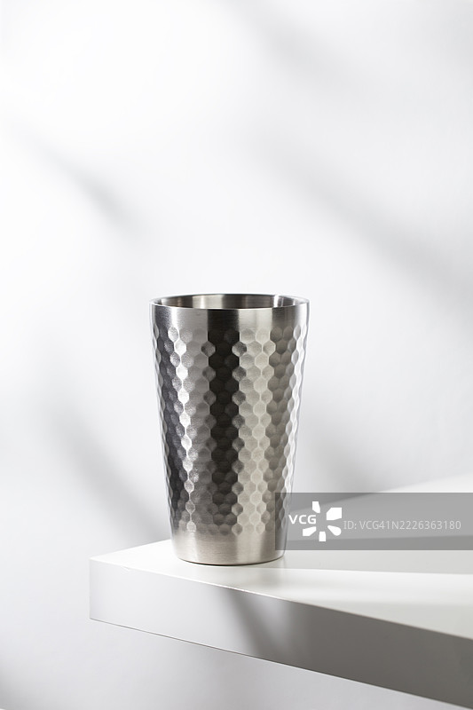 白色桌子上的不锈钢杯，配有现代清洁的照明，曼谷，泰国图片素材