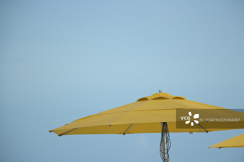低角度视图的黄色阳伞与晴朗的天空，开曼群岛，开曼岛图片素材