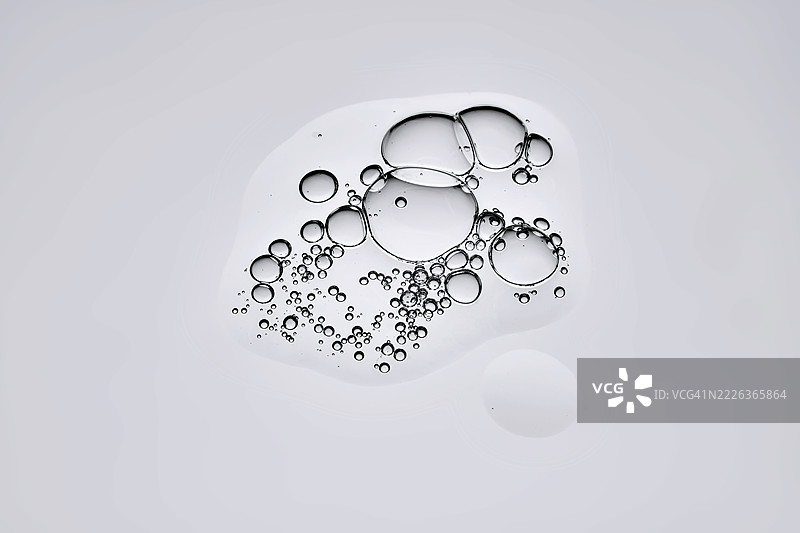 一滴美丽的精华液在灰色背景上图片素材