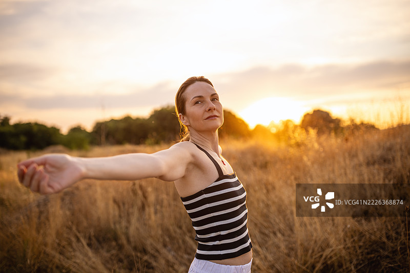 女人怀着感激之情享受日落图片素材