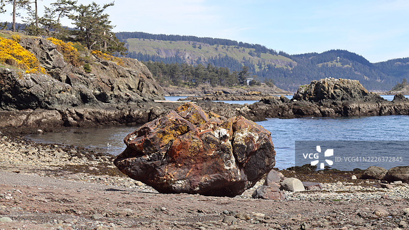 加拿大不列颠哥伦比亚省南海湾群岛彭德岛海滩上的五彩斑斓的岩石图片素材