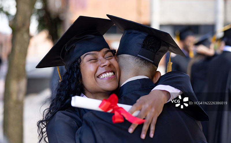 快乐的毕业生们在庆祝毕业时相拥而抱图片素材