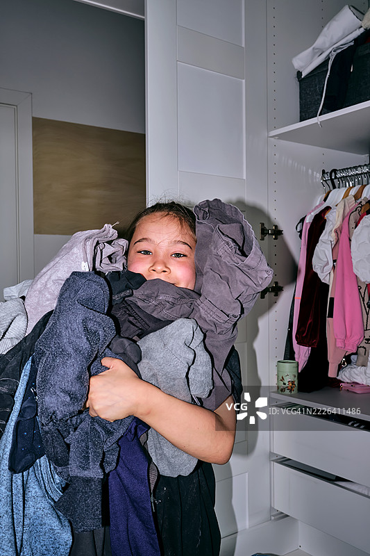 女孩整理她的衣橱，里面有很多东西。图片素材
