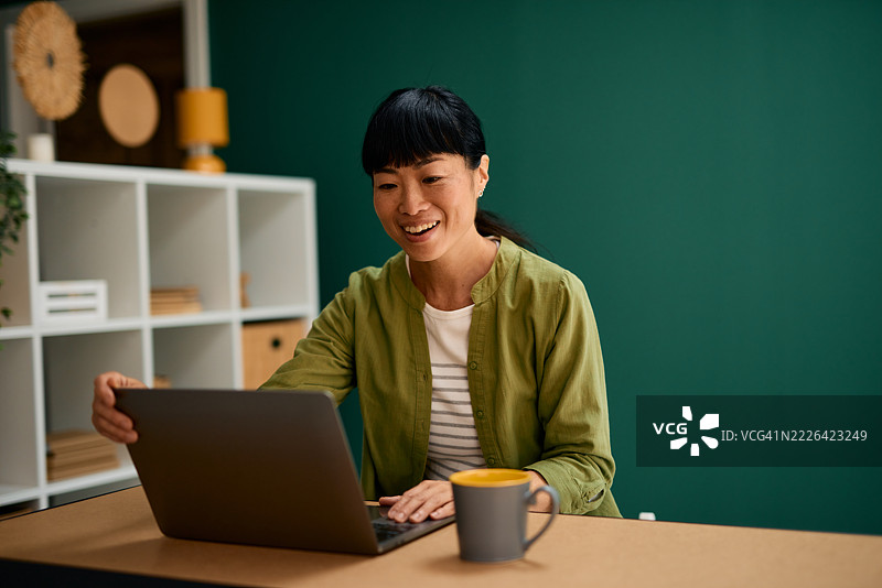 亚洲自由职业者在家办公使用笔记本电脑图片素材
