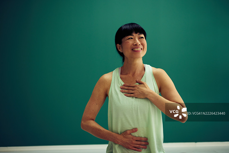 成熟的亚洲女性双手放在胸部和腹部练习呼吸练习图片素材