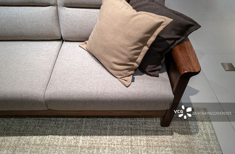 灰色沙发配有棕色靠垫，木质框架图片素材