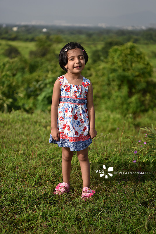 在大自然中站着的可爱表情女孩图片素材