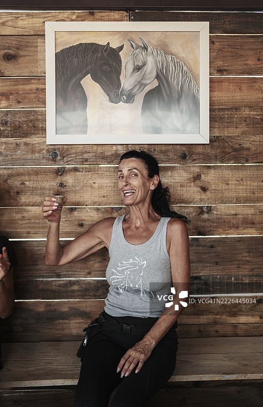 成熟的女性在骑马远足后喝饮料图片素材