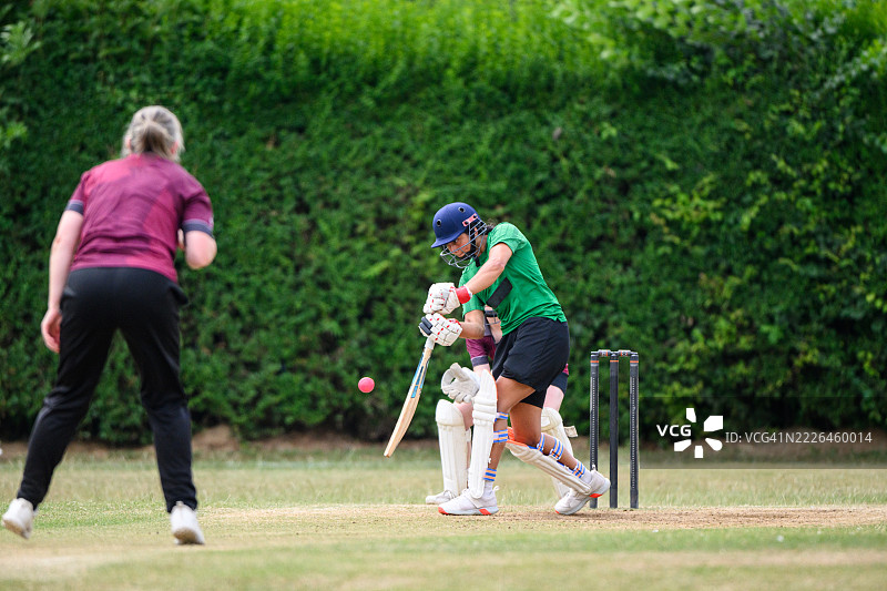 坚定的少女击球手在比赛中击打板球图片素材