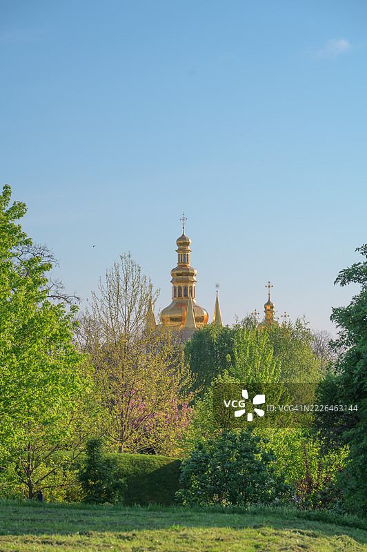 春天，东正教教堂的金色圆顶在绿树之上高高耸立。图片素材