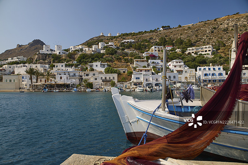 海港,停泊着渔船,白色房屋环绕在湛蓝的海水中,潘代利城堡,城堡,莱罗斯城堡,圣约翰城堡,阿皮蒂基山,潘代利湾,风车,莱罗斯,佐泽卡尼撒群岛,希腊岛屿,希腊图片素材