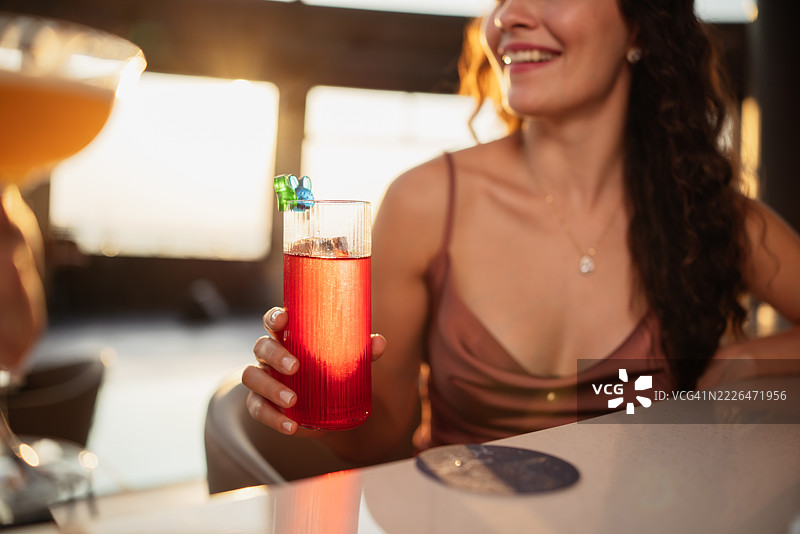 微笑的女性手持红色鸡尾酒图片素材