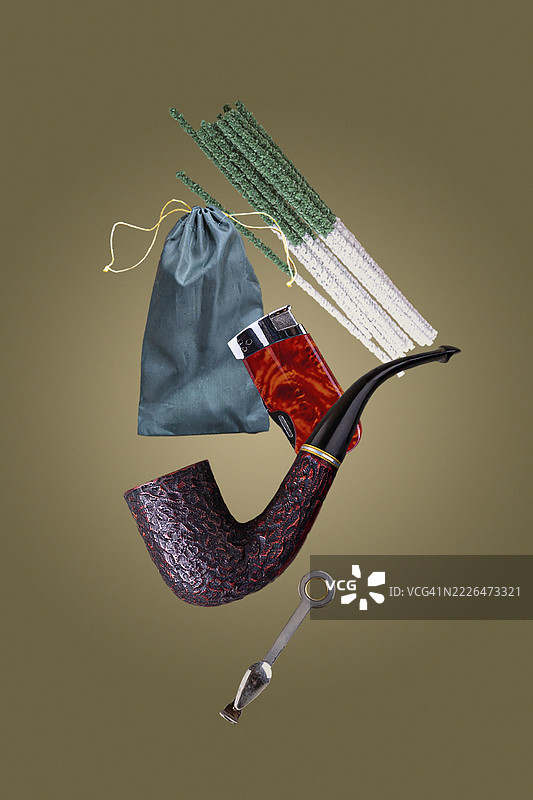 烟斗、打火机、烟草袋、清洁配件、在棕色背景上的飞行物体图片素材