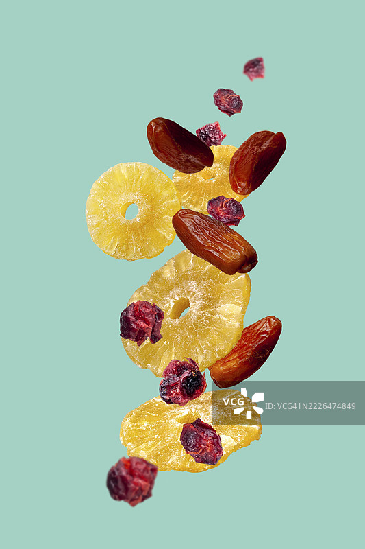 蓝色背景上的干果 - 菠萝、枣和蔓越莓图片素材