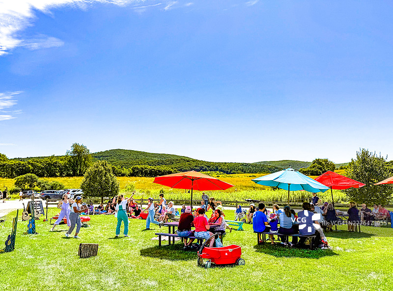 人们在公园的五彩伞下吃午餐图片素材