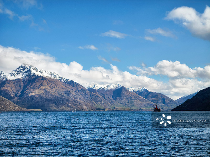 瓦卡蒂普湖上的蒸汽船，背景是新西兰奥塔哥地区皇后镇的山景图片素材