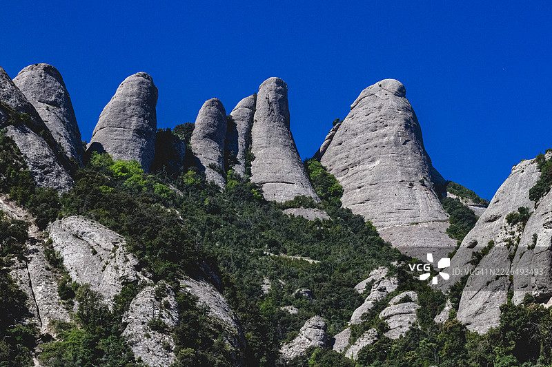 低角度视图的岩石与蓝天，蒙特塞拉特，瓦伦西亚自治区图片素材