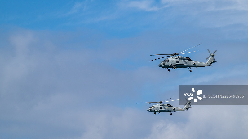 两架西班牙海军西科斯基MH-60F海鹰直升机在多云的天空中飞行图片素材