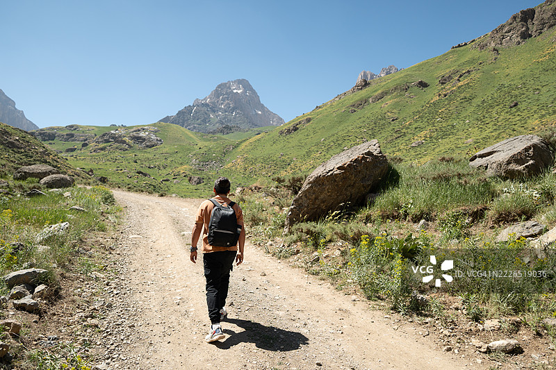 年轻男子在奇洛山脉的土路上徒步旅行图片素材