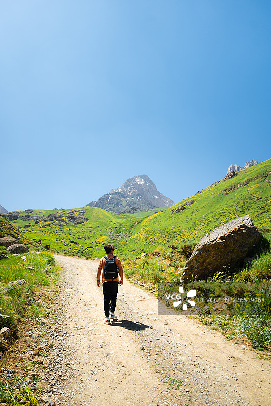 年轻男子在哈卡里的一条土路上徒步前往西洛山图片素材
