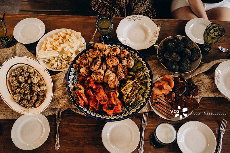 餐饮公司为派对准备一张摆满烤鸡和蔬菜的桌子图片素材
