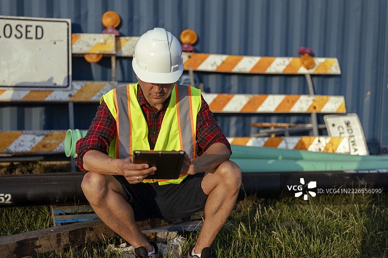男性工程师在施工现场使用数字平板收集管道数据图片素材