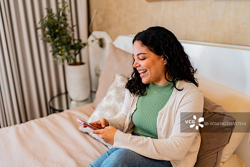 年轻女性在家中使用手机图片素材