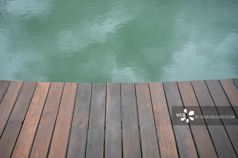 木栈道延伸至绿色水面图片素材