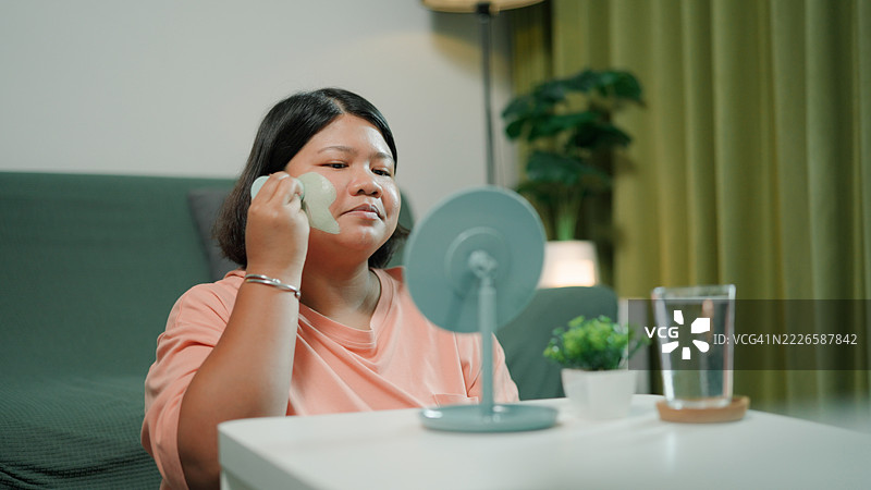 亚洲女性在客厅护理她的皮肤图片素材
