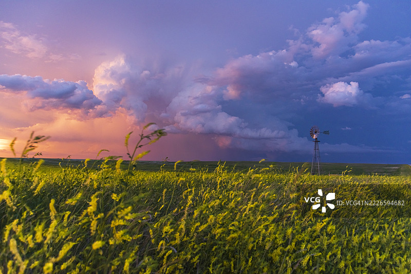 蒙大拿州高原上的雷暴日落云彩与风车。图片素材