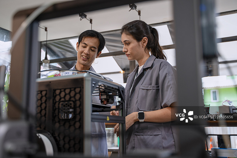 男性医生和女性工程师正在讨论3D打印的人工植入物。图片素材