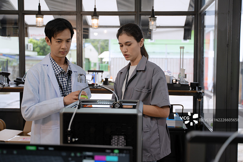 男性医生和女性工程师正在讨论3D打印的人工植入物。图片素材