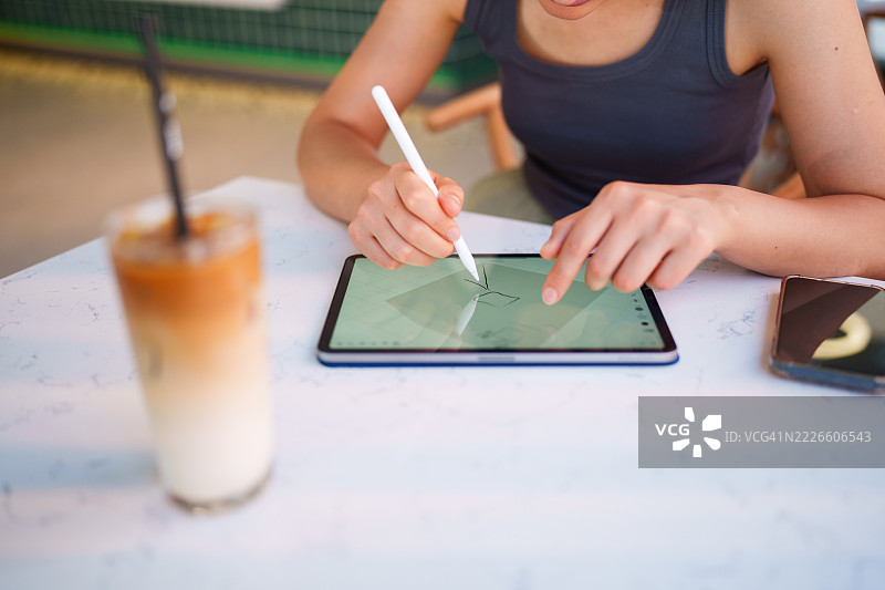 女性顾客在咖啡馆使用数字平板和数字笔图片素材
