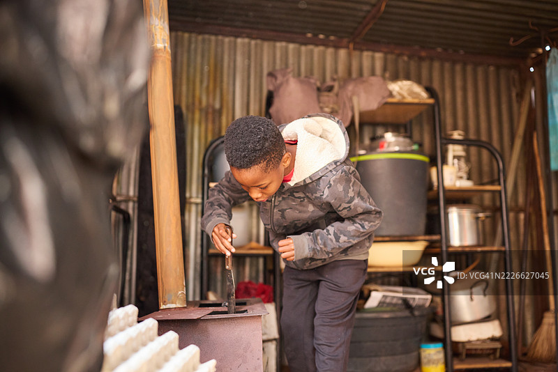 南非索韦托的家庭环境中，男孩参与日常家务。图片素材