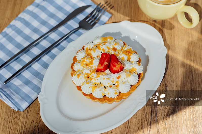 美味的草莓挞配鲜奶油和卡布奇诺，摆放在木桌上图片素材