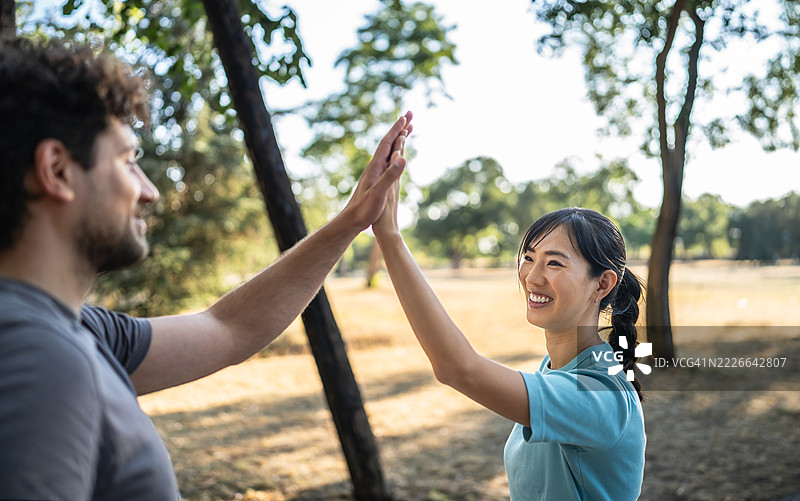 年轻情侣在公园锻炼后击掌庆祝图片素材