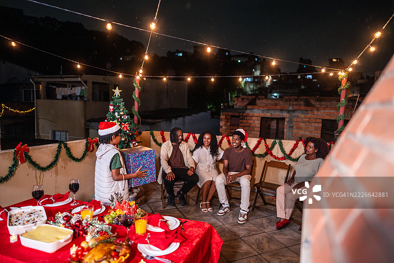 儿子在房顶上给母亲送圣诞礼物图片素材